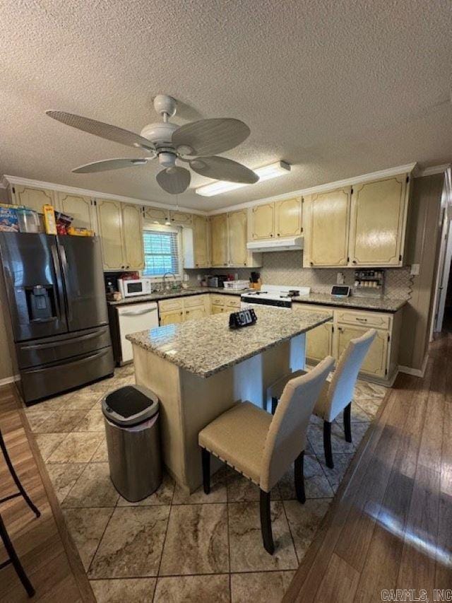 kitchen featuring white appliances, a center island, ceiling fan, and light hardwood / wood-style flooring