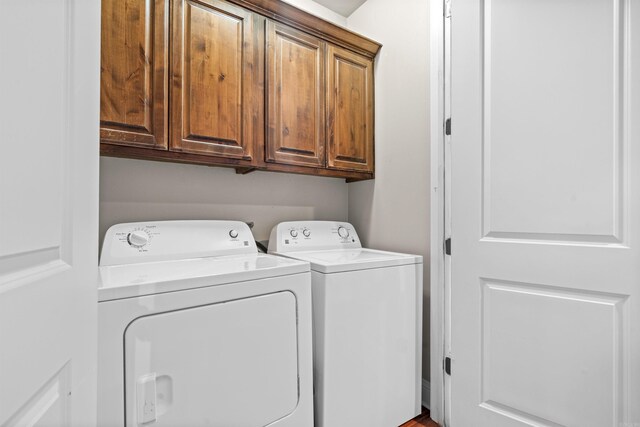 washroom featuring washing machine and dryer and cabinets