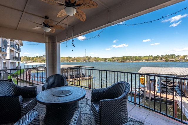 balcony featuring a water view and ceiling fan