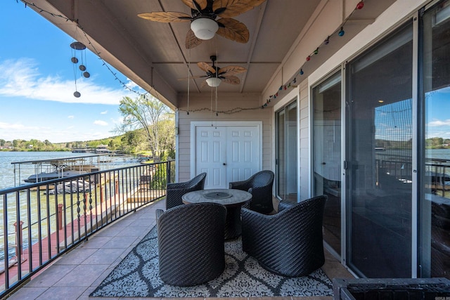 balcony featuring ceiling fan and a water view