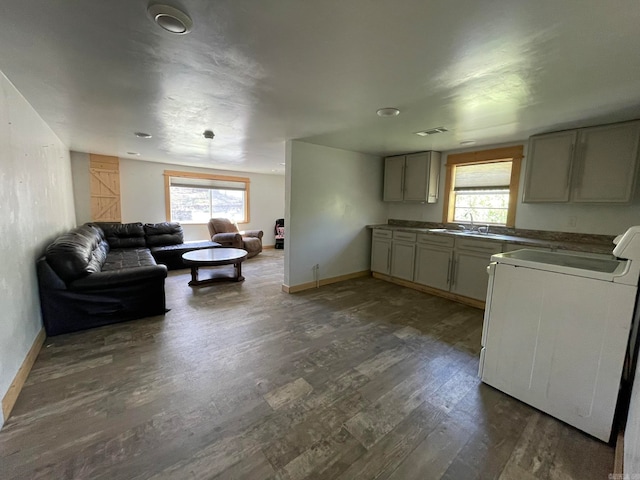 kitchen with sink, stove, dark hardwood / wood-style floors, and a wealth of natural light