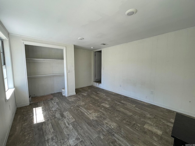 unfurnished bedroom featuring a closet and dark wood-type flooring