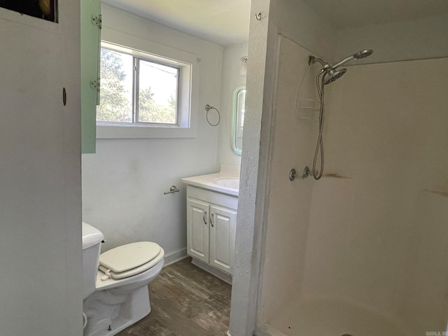 bathroom with a shower, toilet, hardwood / wood-style floors, and vanity