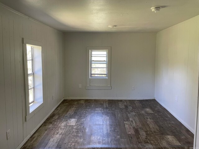 unfurnished room featuring a healthy amount of sunlight and dark hardwood / wood-style floors