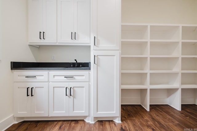 bar featuring white cabinets, dark hardwood / wood-style floors, and sink