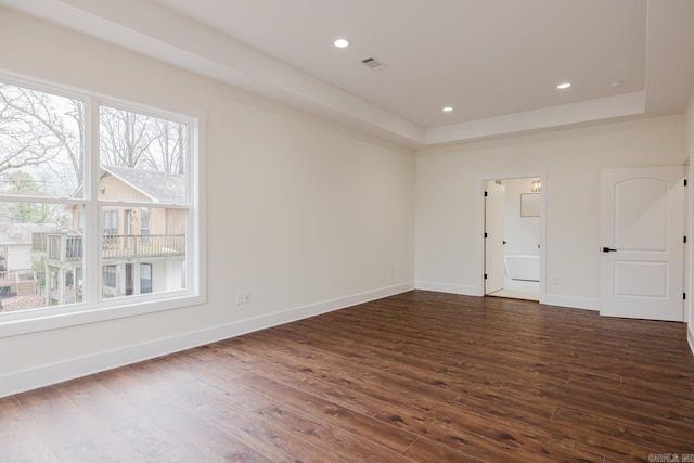 unfurnished room featuring dark hardwood / wood-style flooring and a raised ceiling