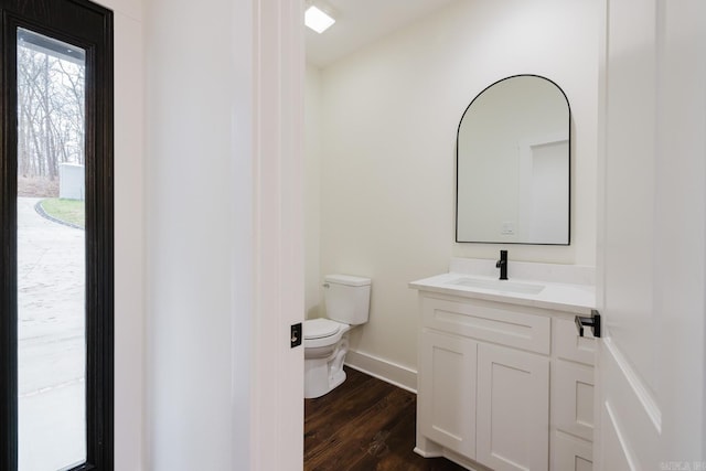 bathroom with toilet, vanity, and hardwood / wood-style flooring