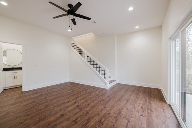 unfurnished living room featuring ceiling fan and dark wood-type flooring