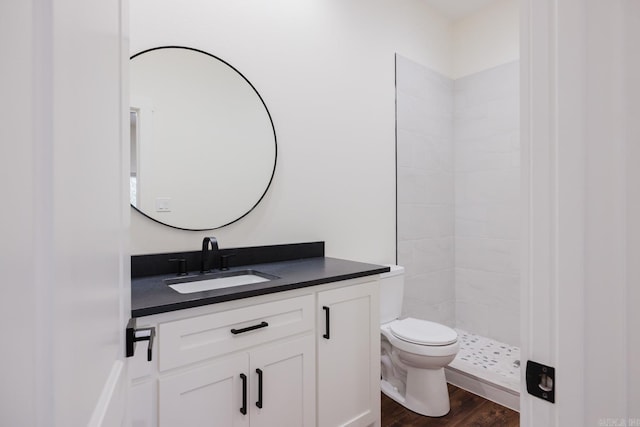 bathroom with toilet, a shower, wood-type flooring, and vanity