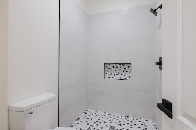 bathroom featuring toilet and tiled shower