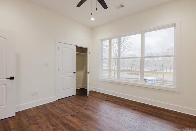 unfurnished bedroom with ceiling fan, dark hardwood / wood-style floors, and a closet