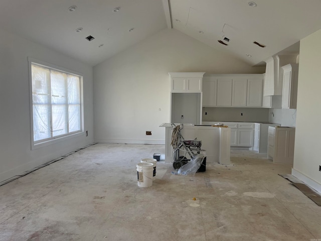 kitchen featuring white cabinetry, premium range hood, and high vaulted ceiling