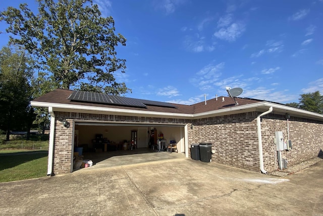 500 E Ingram St, E Camden, AR 71701 - view of home's exterior with solar panels, brick siding, a garage, and concrete driveway