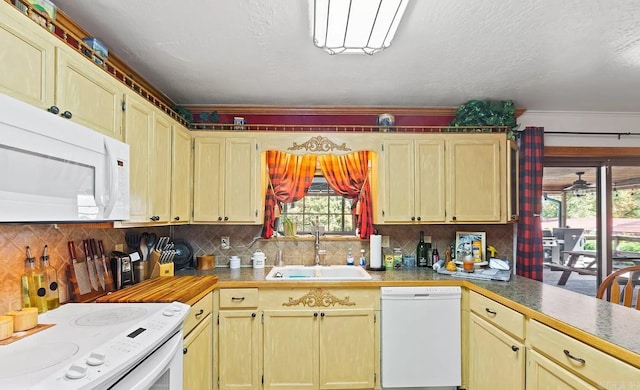 kitchen featuring white appliances, sink, and backsplash