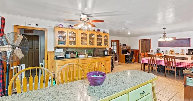 kitchen featuring ornamental molding, ceiling fan with notable chandelier, light tile floors, and pendant lighting