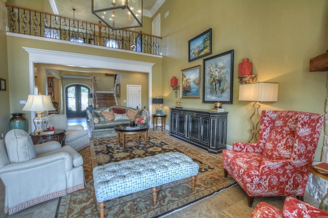 tiled living room featuring french doors, ornamental molding, and a towering ceiling