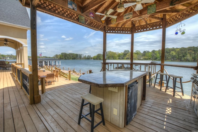 dock area featuring a deck with water view and an outdoor bar