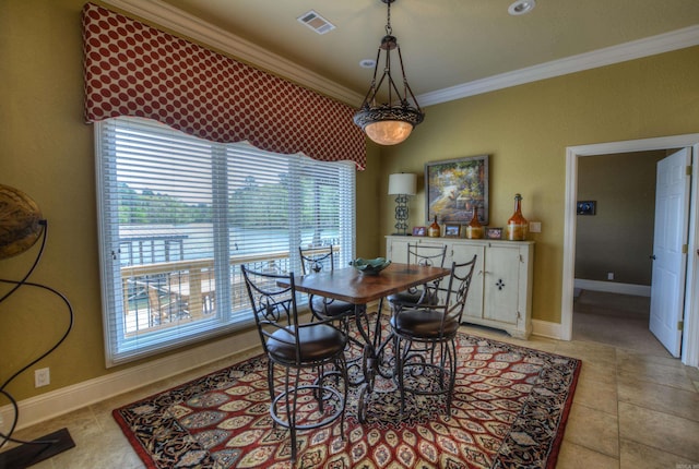 dining space with light tile floors and crown molding