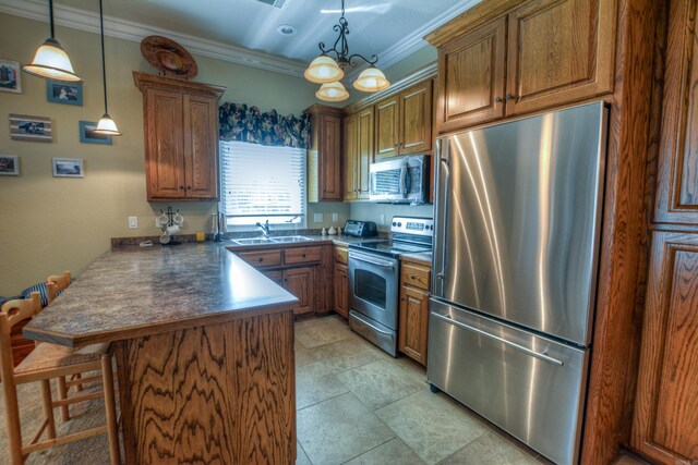 kitchen featuring appliances with stainless steel finishes, a breakfast bar area, kitchen peninsula, a notable chandelier, and pendant lighting