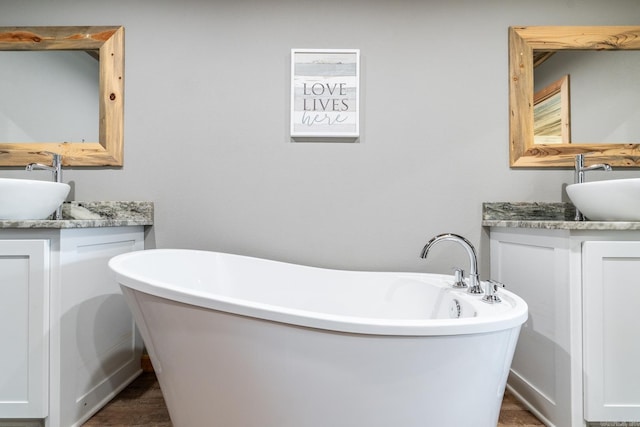 bathroom with vanity and a bath