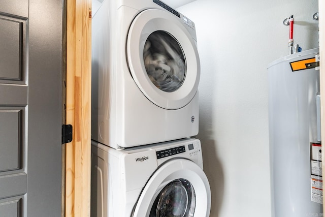 laundry room with stacked washer / dryer and water heater