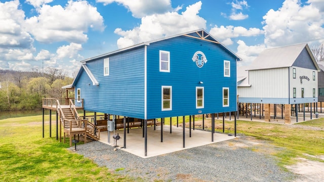 back of house with a carport and a yard