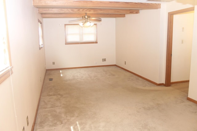 carpeted empty room with ceiling fan and beam ceiling