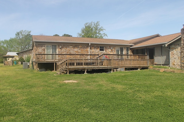 back of property with central AC unit, a wooden deck, and a lawn