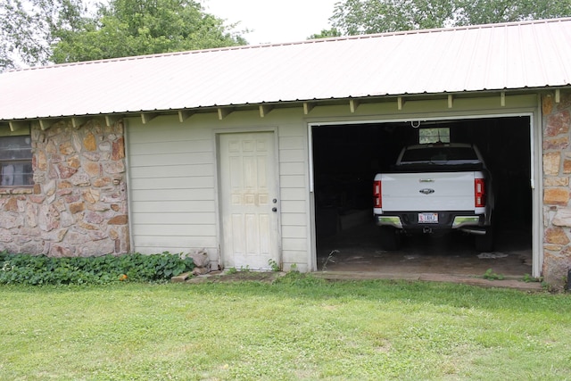 view of outbuilding with a yard and a garage