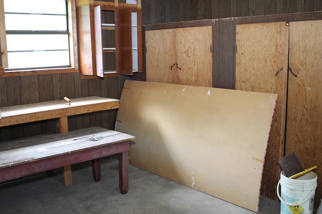 interior space featuring concrete flooring and wood walls