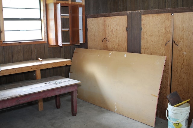 interior space with concrete flooring and wood walls