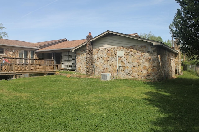 rear view of house with a deck and a lawn