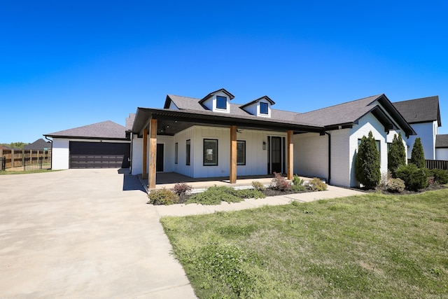 view of front of property with covered porch, a front yard, and a garage