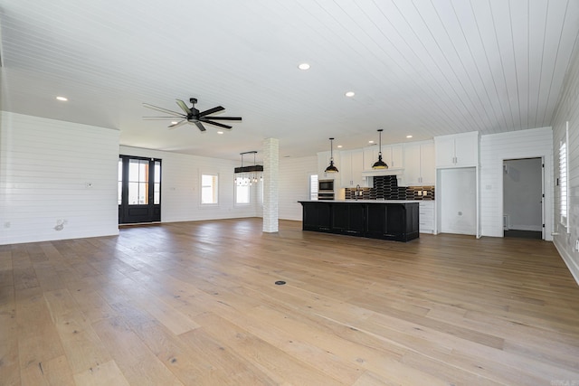 unfurnished living room with ceiling fan, sink, and light wood-type flooring