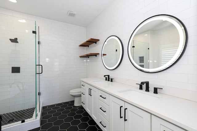 bathroom with dual vanity, toilet, tile floors, and an enclosed shower