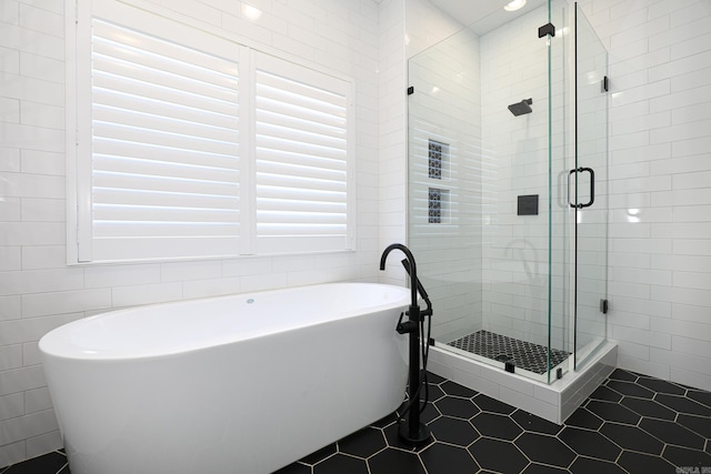 bathroom with tile flooring, plus walk in shower, and tile walls