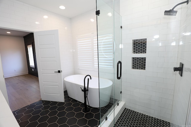 bathroom featuring tile walls, hardwood / wood-style flooring, and independent shower and bath