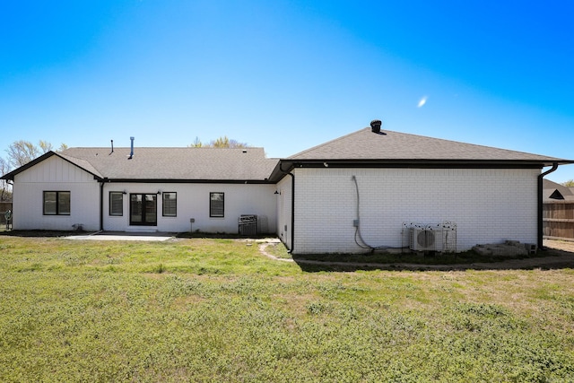 back of property with a patio, central AC, and a lawn