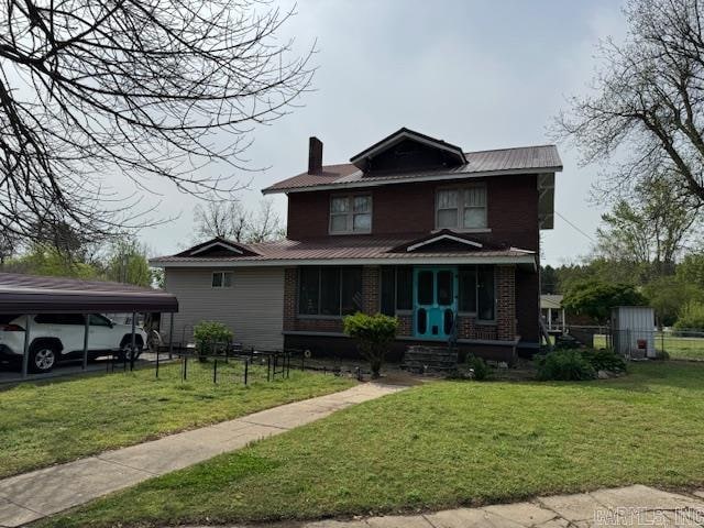 front facade with covered porch, a storage unit, and a front yard