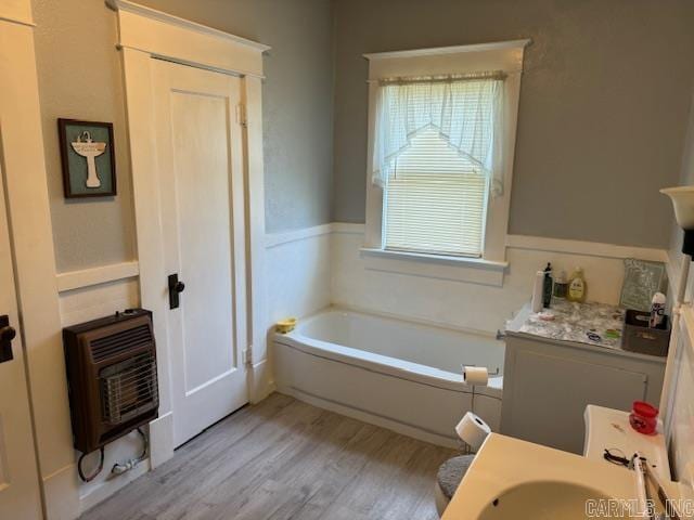 bathroom with sink, hardwood / wood-style flooring, and a bath