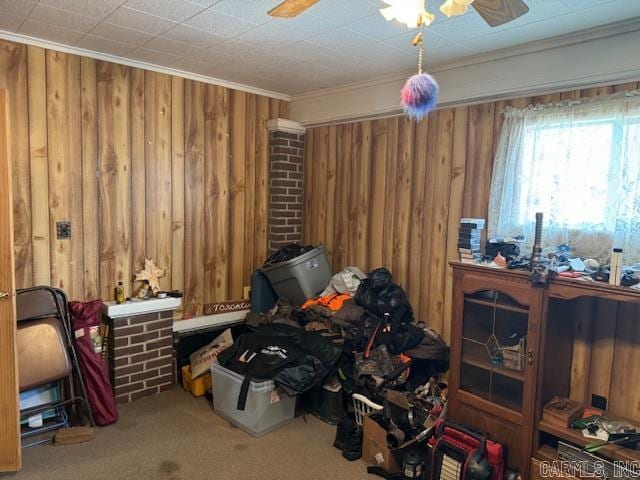 miscellaneous room featuring light colored carpet, ceiling fan, brick wall, and ornamental molding