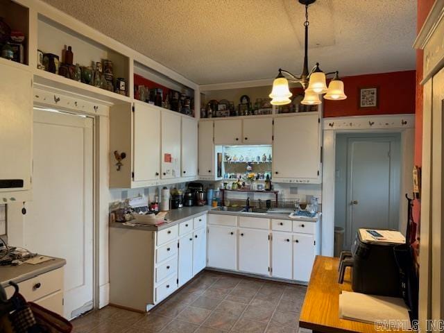 kitchen featuring a chandelier, pendant lighting, tile floors, and white cabinets