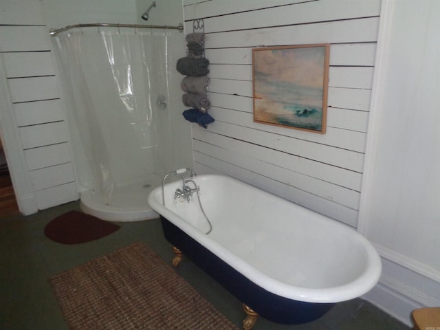 bathroom featuring wood walls, a soaking tub, and a shower stall