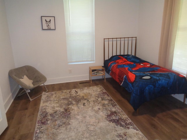 bedroom with dark wood-style floors and baseboards