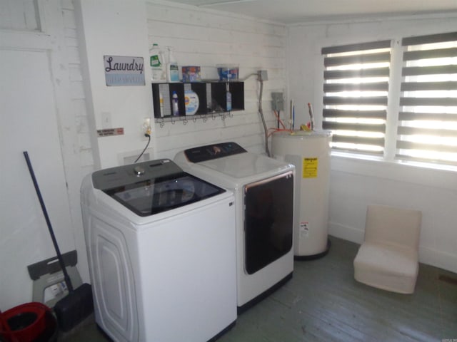 washroom featuring water heater, laundry area, dark wood-type flooring, and washer and clothes dryer