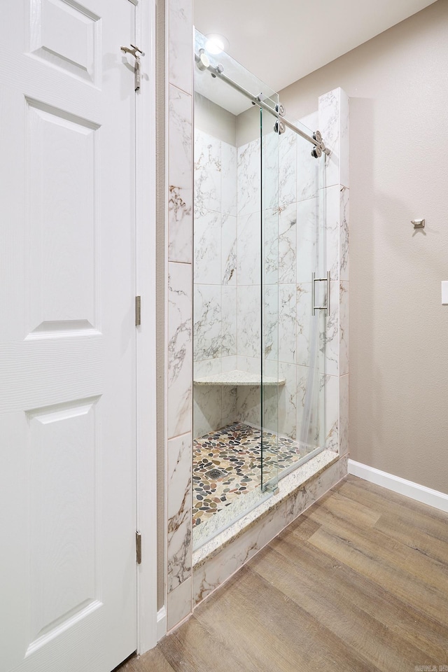 bathroom with hardwood / wood-style floors and a shower with shower door