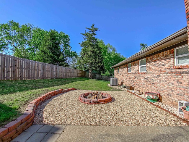 view of yard with an outdoor fire pit and central air condition unit