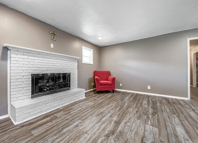 unfurnished room with wood-type flooring and a fireplace