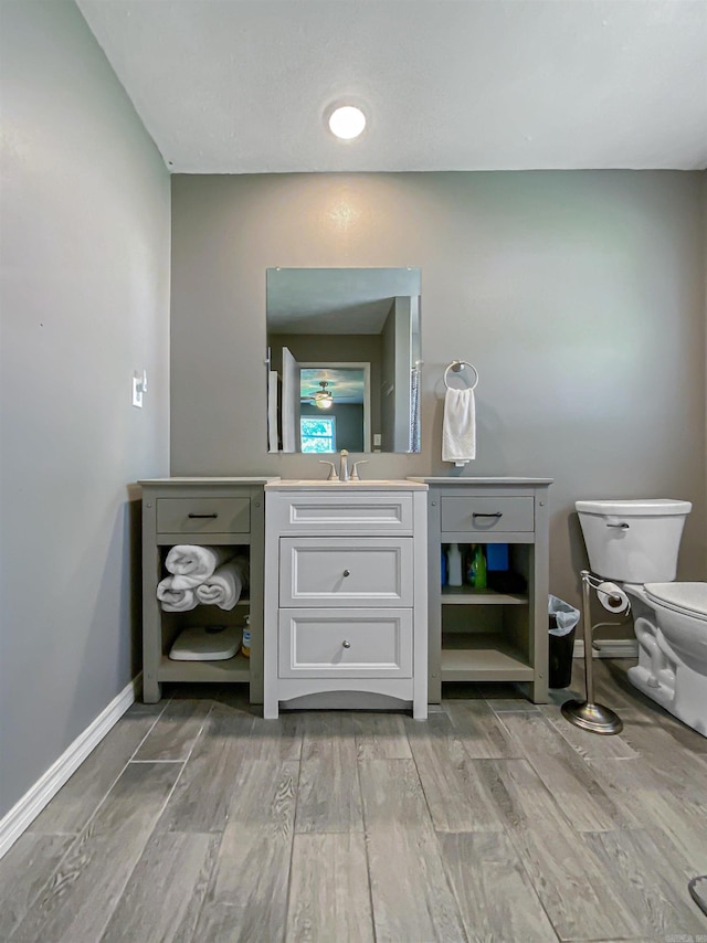 bathroom featuring wood-type flooring, vanity, and toilet