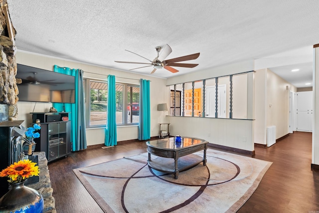 living room featuring ceiling fan, dark hardwood / wood-style flooring, and a textured ceiling